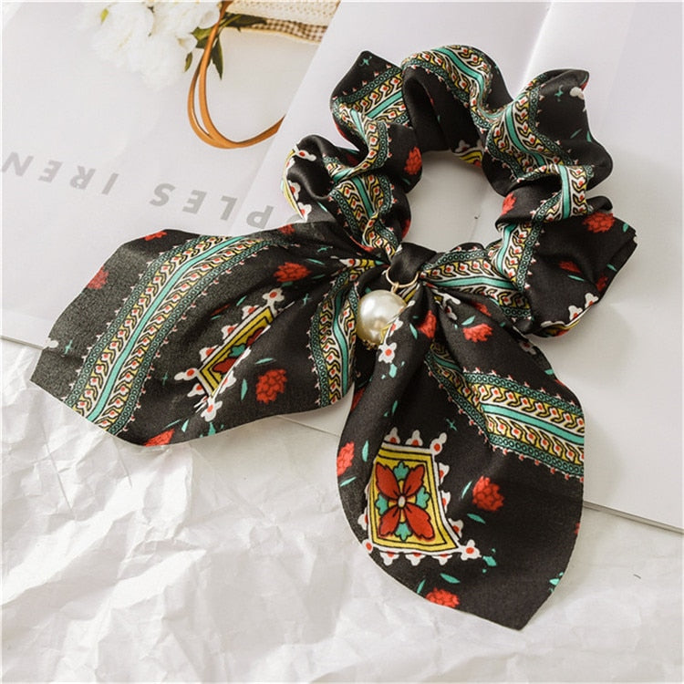 Scrunchie de cheveux avec nœud et perle.