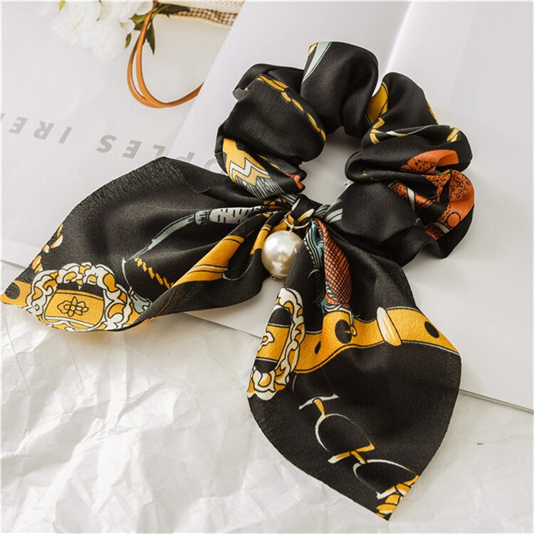 Scrunchie de cheveux avec nœud et perle.