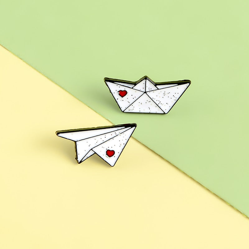 Épingles - avion en papier et bateau