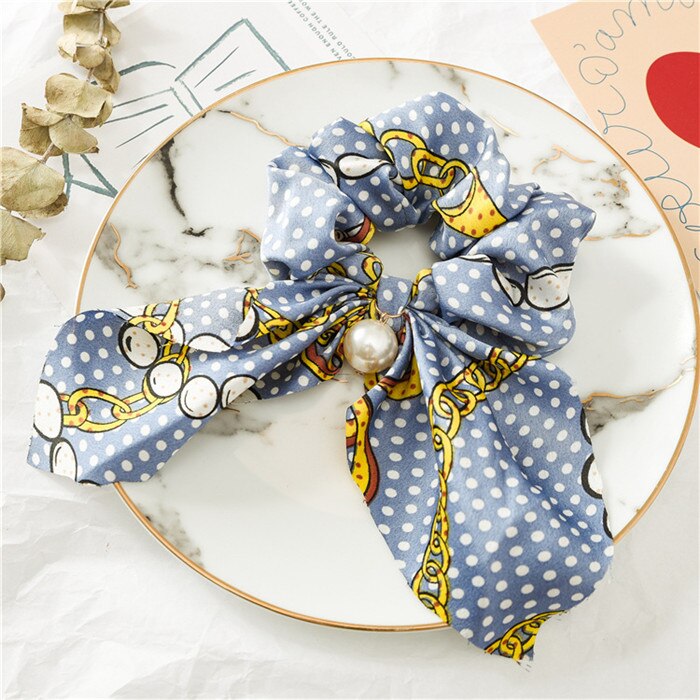 Scrunchie de cheveux avec nœud et perle.