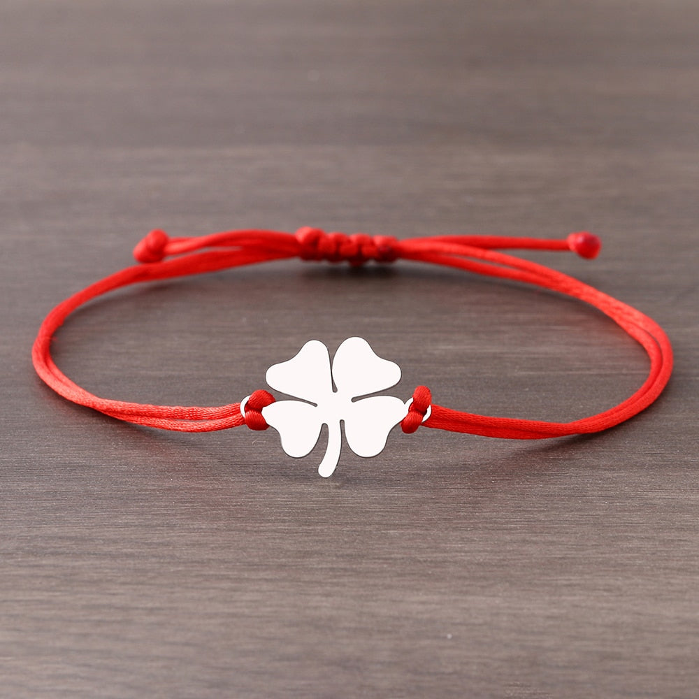 Un bracelet sur une ficelle avec un trèfle à quatre feuilles.