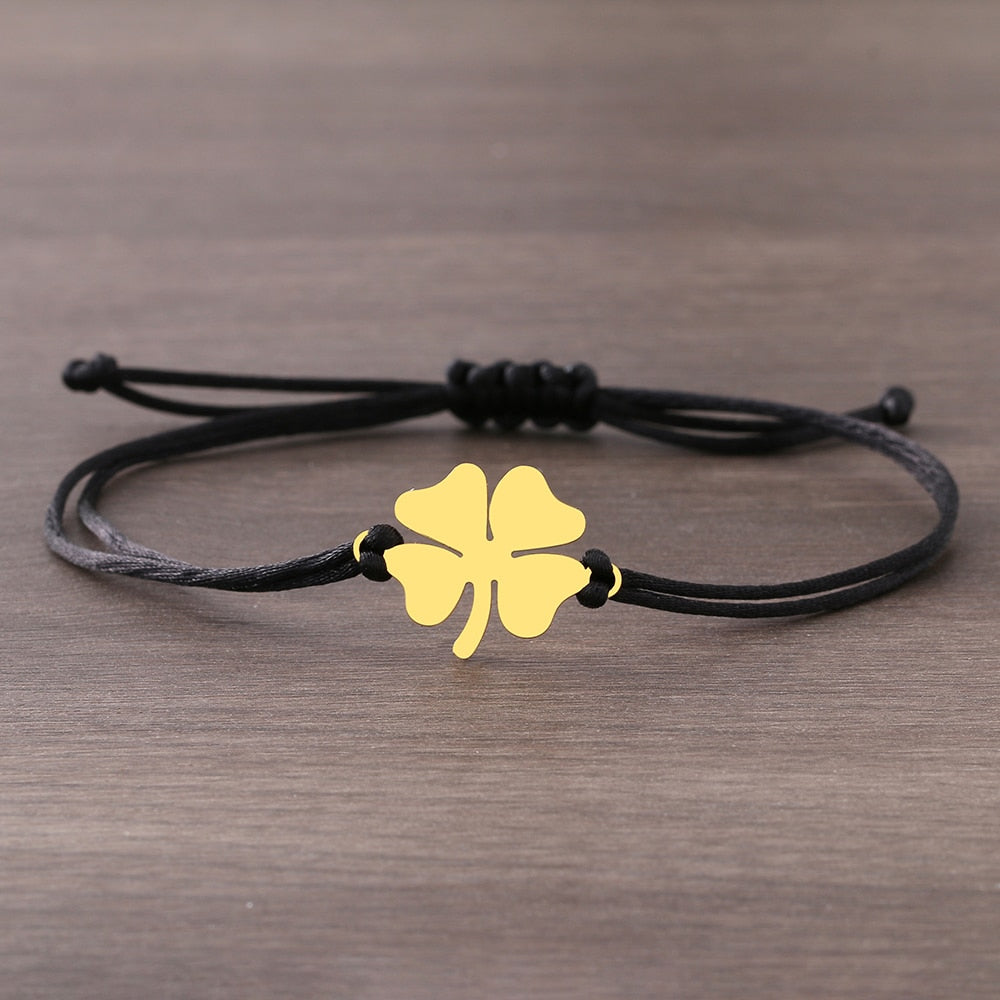 Un bracelet sur une ficelle avec un trèfle à quatre feuilles.
