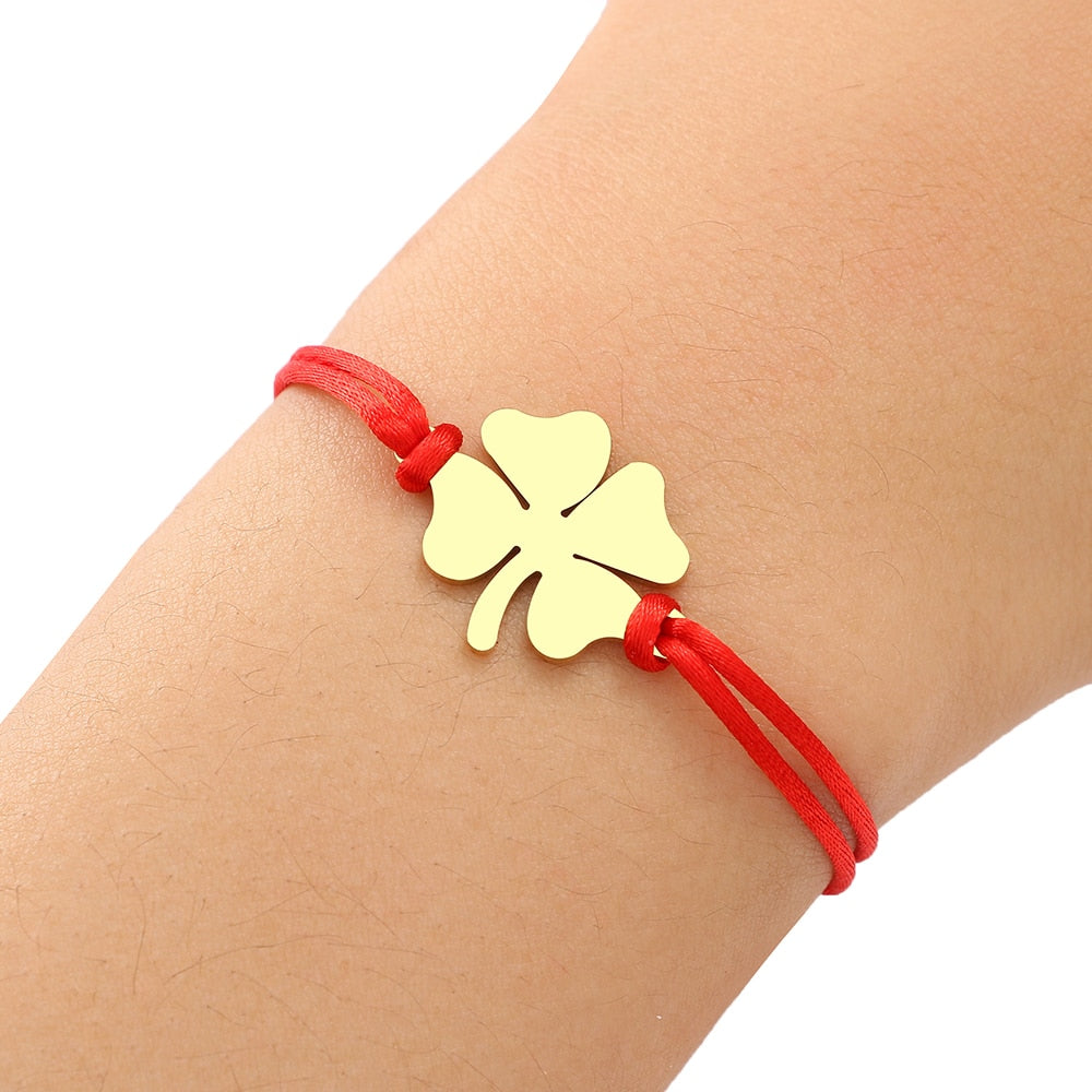 Un bracelet sur une ficelle avec un trèfle à quatre feuilles.