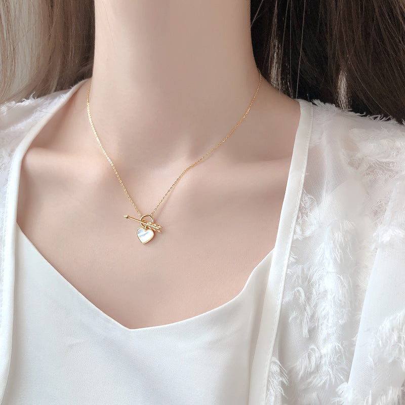 Collier avec un pendentif en forme de cœur et de flèche