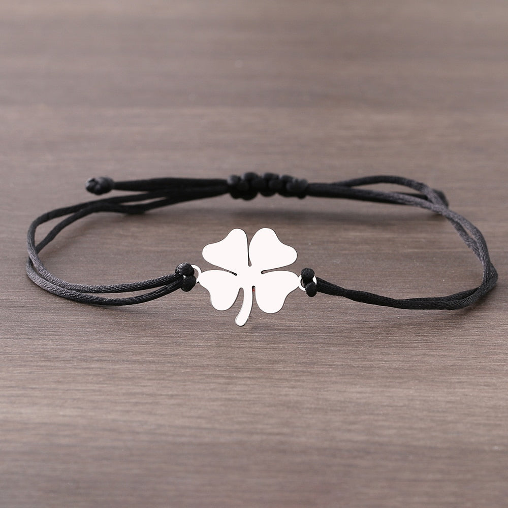 Un bracelet sur une ficelle avec un trèfle à quatre feuilles.