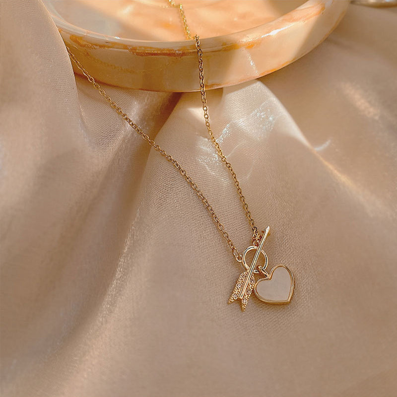 Collier avec un pendentif en forme de cœur et de flèche